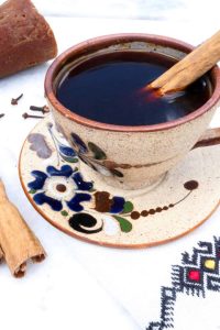 Cafe de Olla in a pottery mug with blue flowers and a cinnamon stick