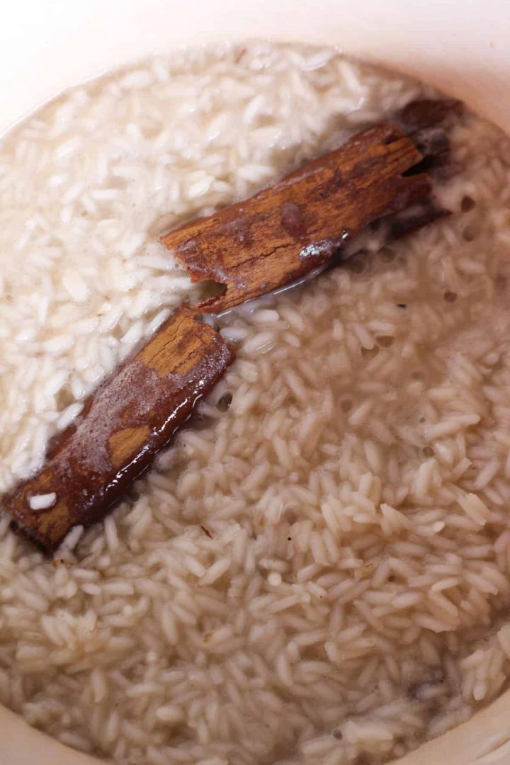 Rice cooking with liquid and cinnamon sticks