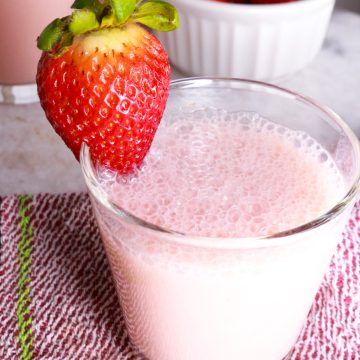 Creamy Strawberry Agua Fresca in a glass with a strawberry garnish