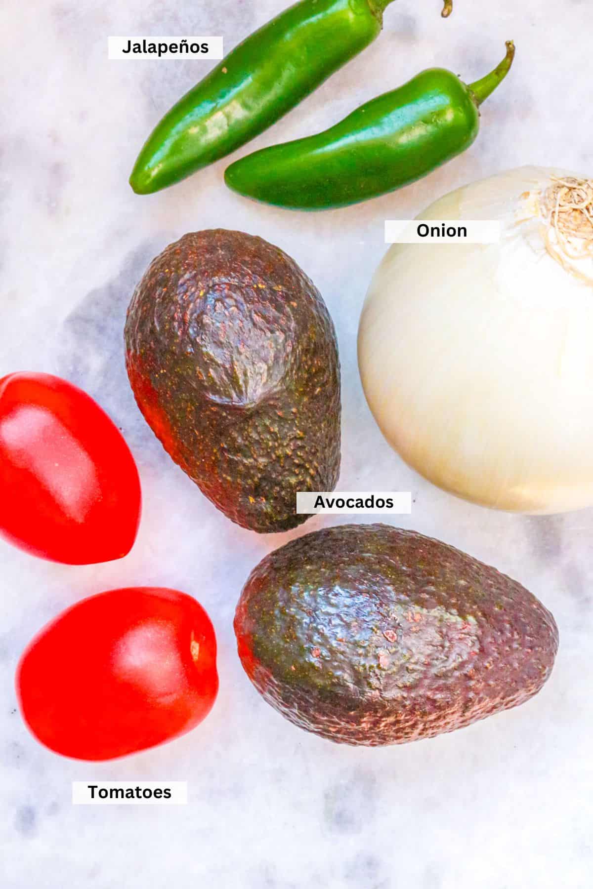 Ingredients for Fire Roasted Guacamole: Jalapeños, avocados, tomatoes and a white onion