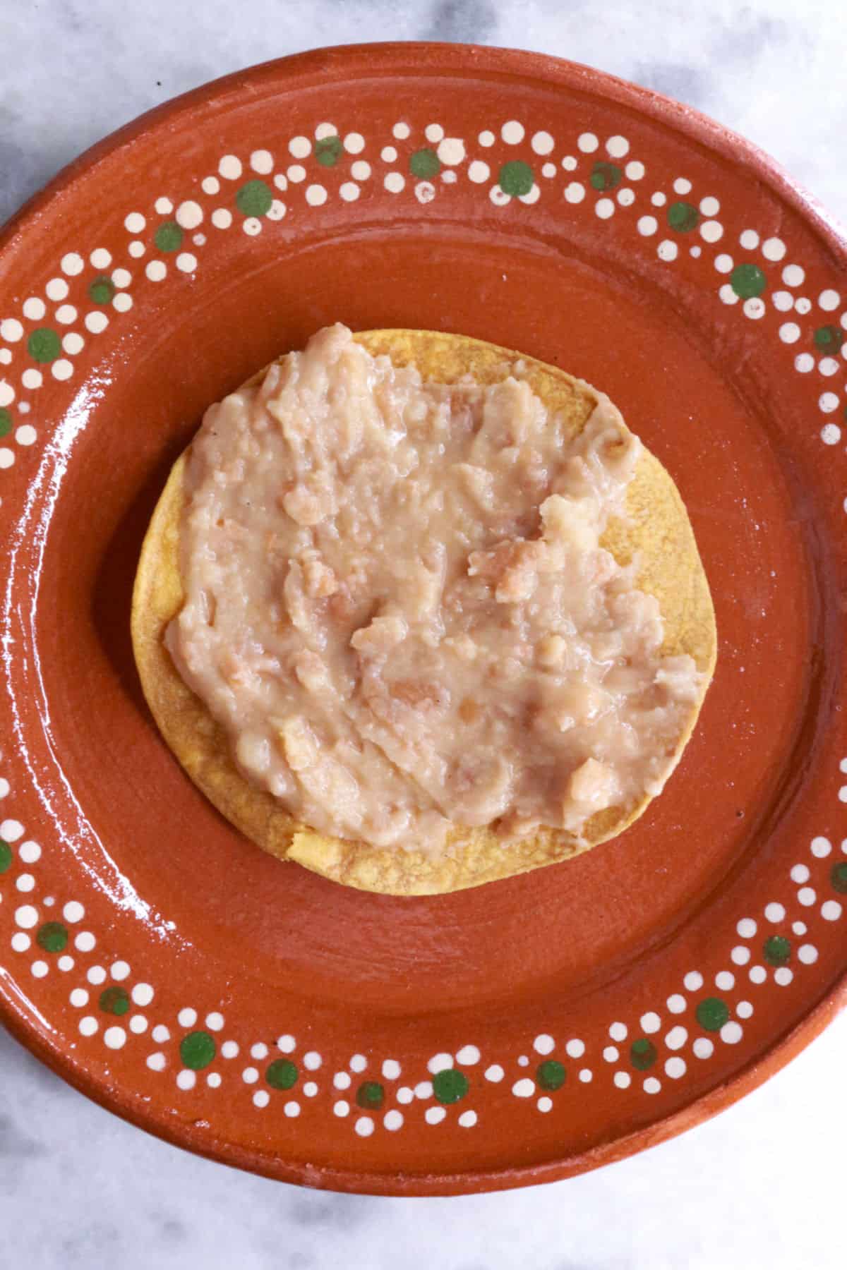 Tostada with a layer of refried beans