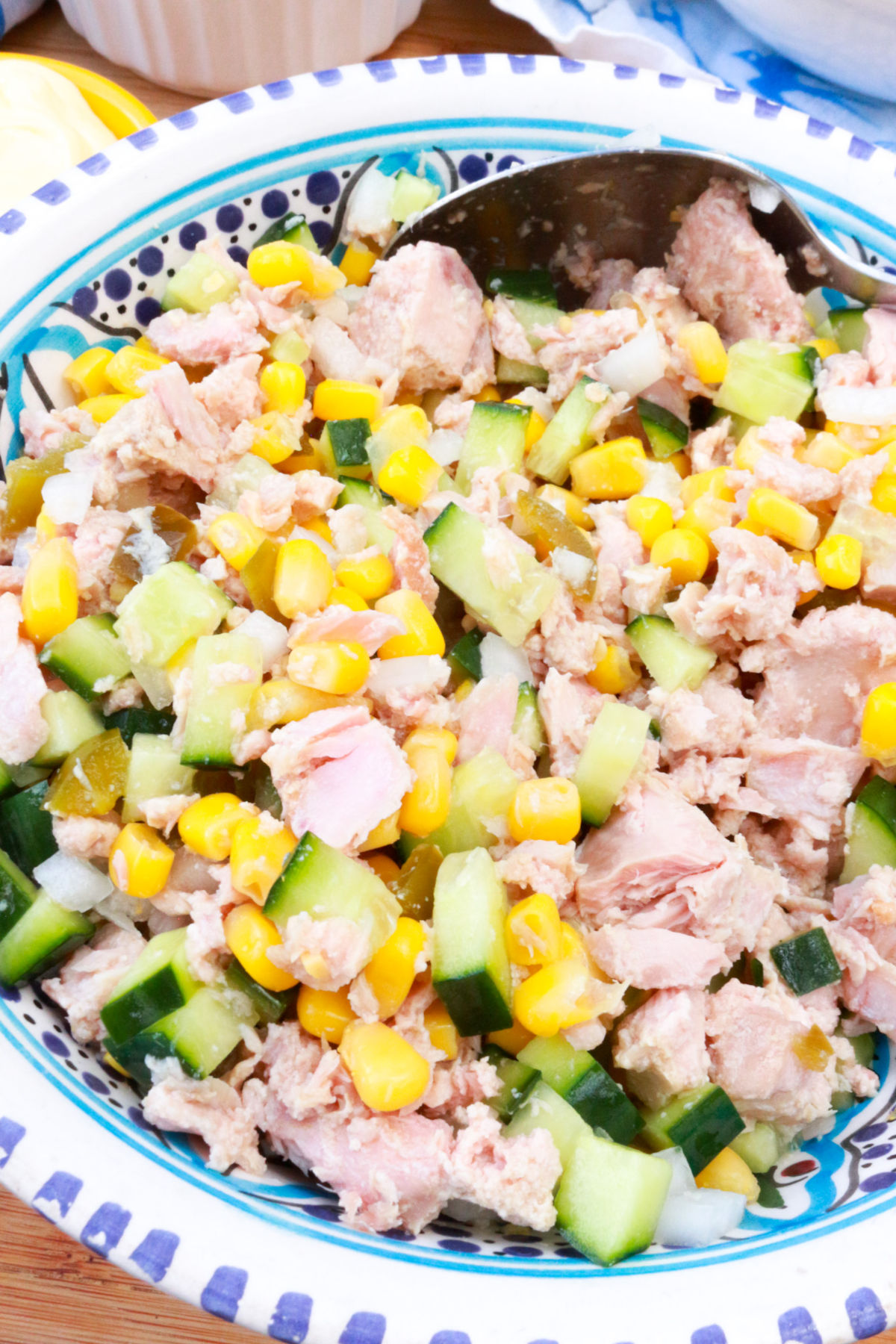 A bowl with tuna, canned corn, diced cucumber, diced onion and diced pickled jalapeños.