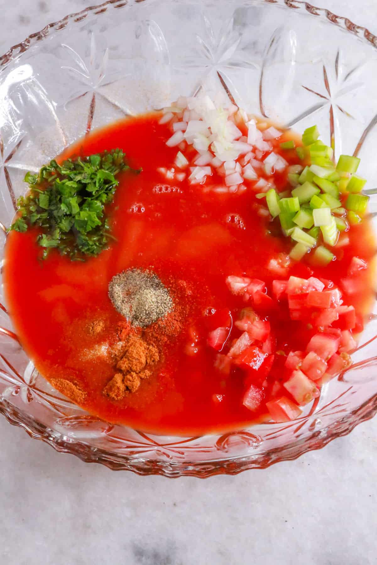 Mixing vegetables, seasonings, and tomato juice for easy Mexican-style shrimp cocktail