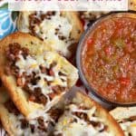 Open-faced ground beef tortas on a platter with a bowl of salsa