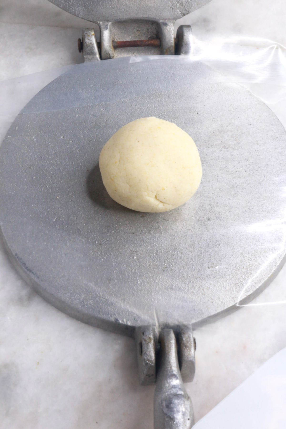 Ball of masa dough on an open tortilla press