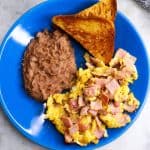 Plate with refried beans, toast and huevos con jamon