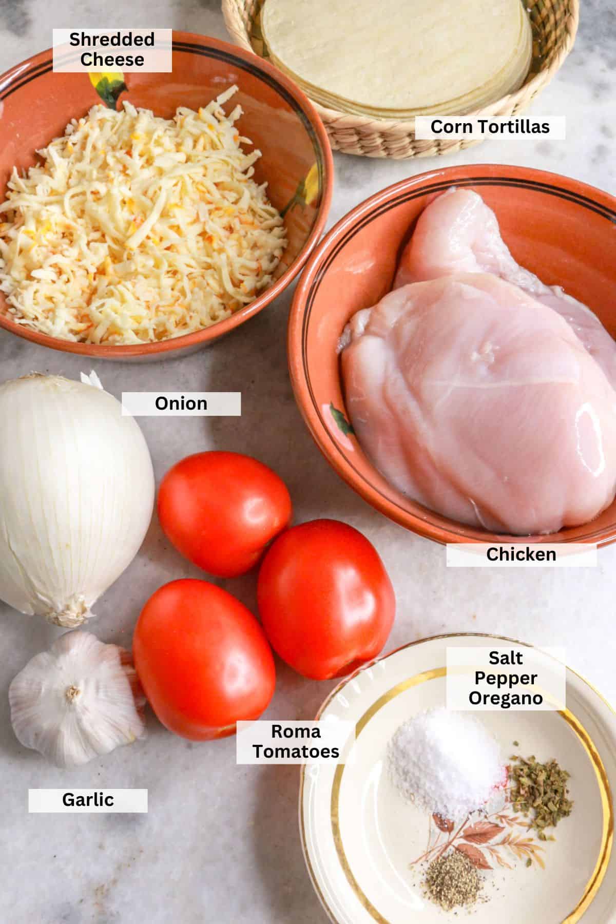 Ingredients for tacos dorados de pollo: shredded cheese, corn tortillas, Roma tomatoes, chicken, onion, garlic, salt, pepper, oregano