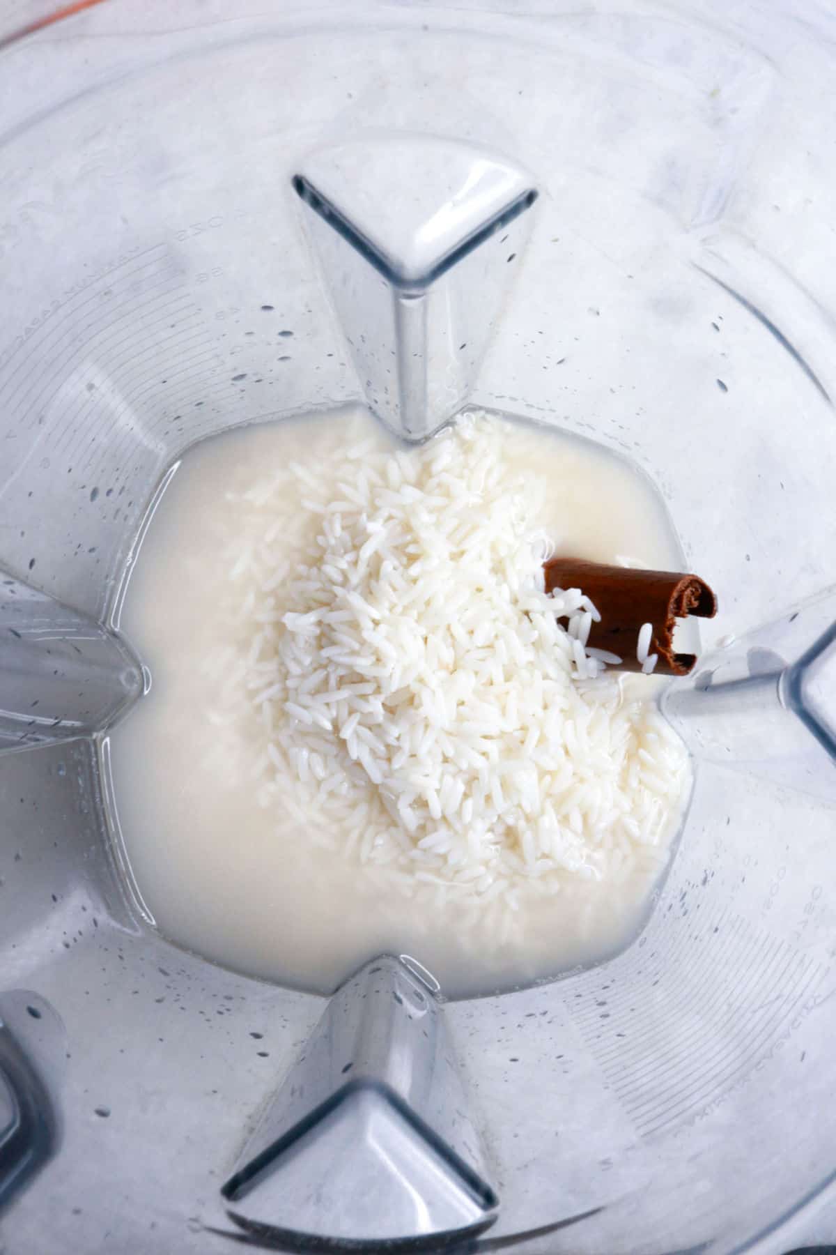 A blender with rice, water and a cinnamon stick