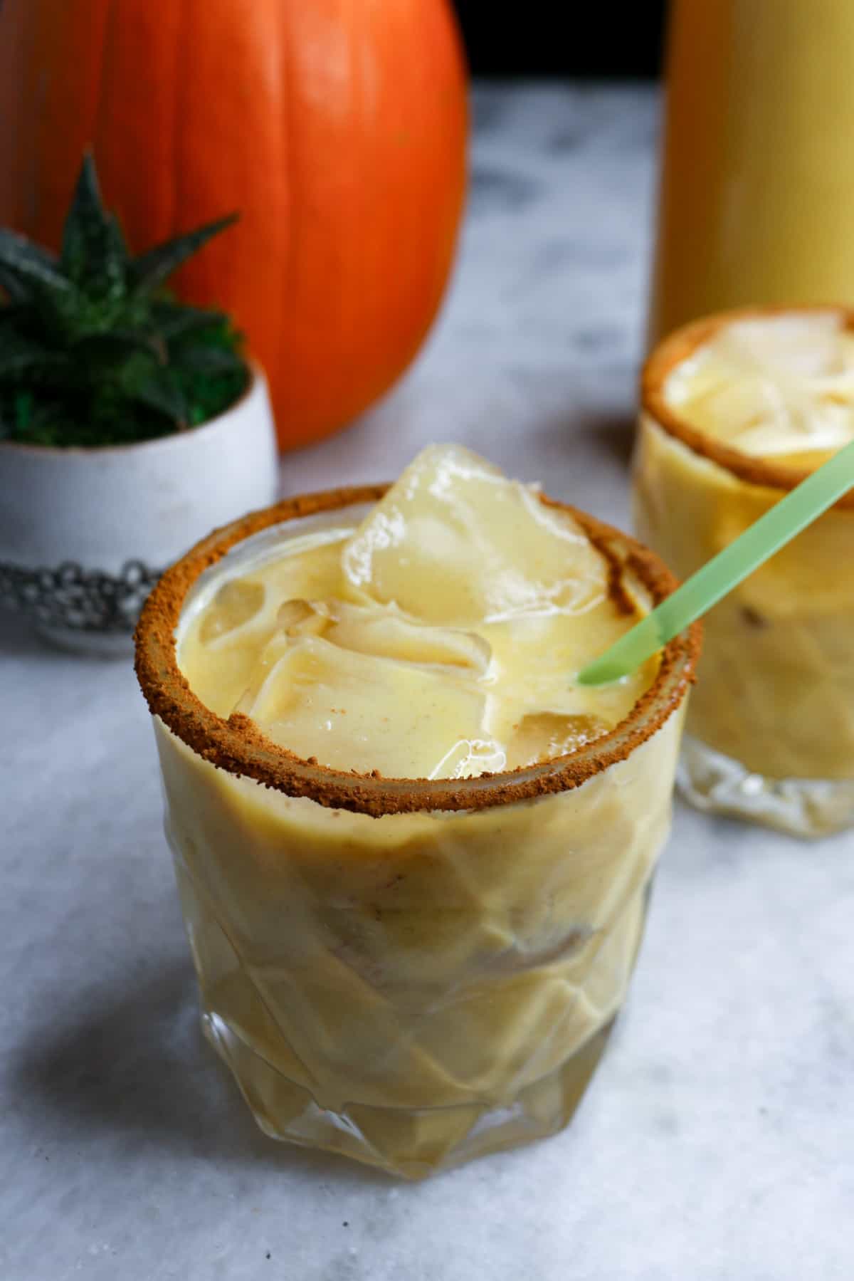 Pumpkin Spice Horchata in a clear glass with a green straw