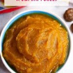 A bowl of puré de calabaza in a bowl surrounded by small piloncillos, a pumpkin, cinnamon stick and cloves
