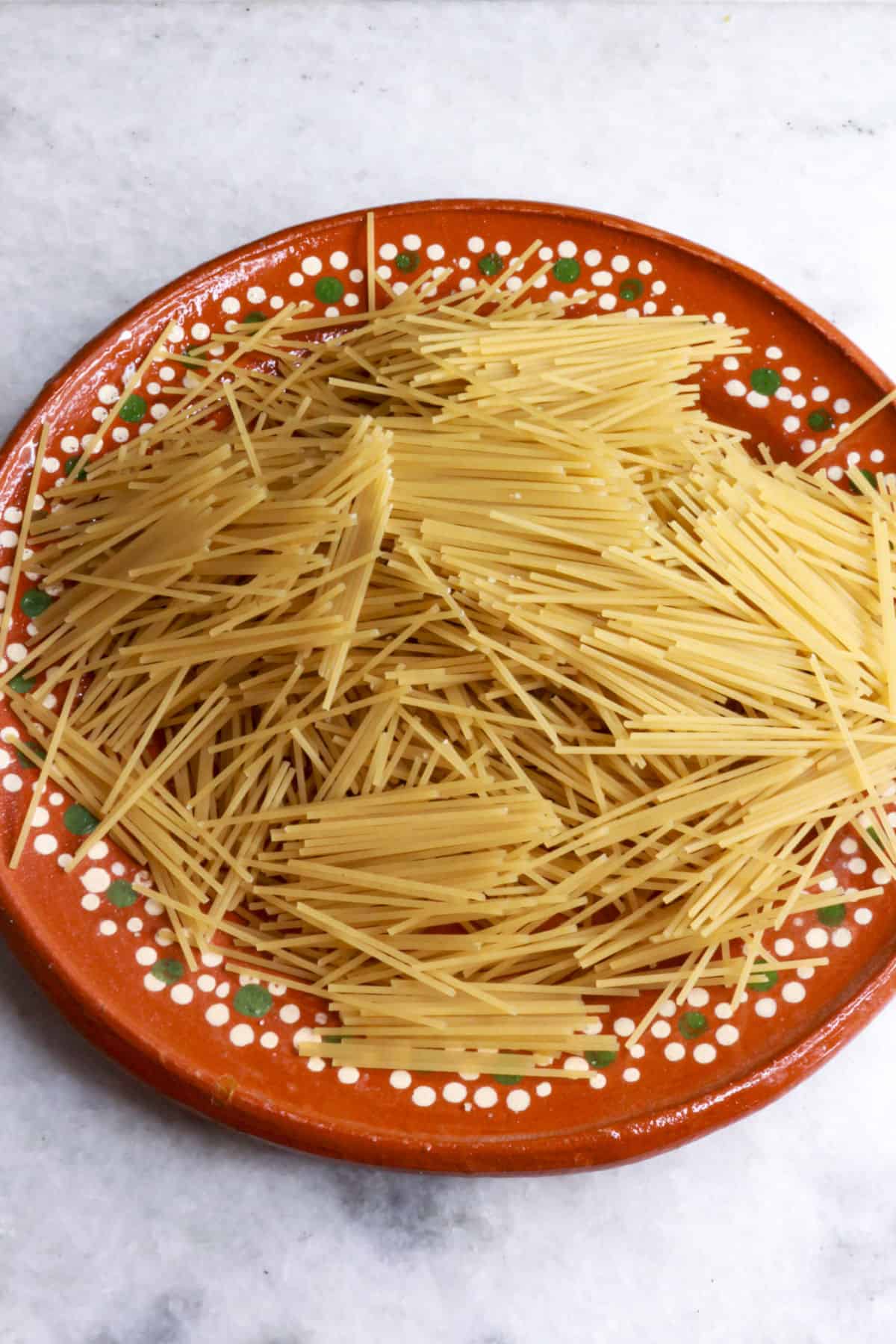 Broken gluten-free noodles in a brown plate ready to be used for sopita de fideo