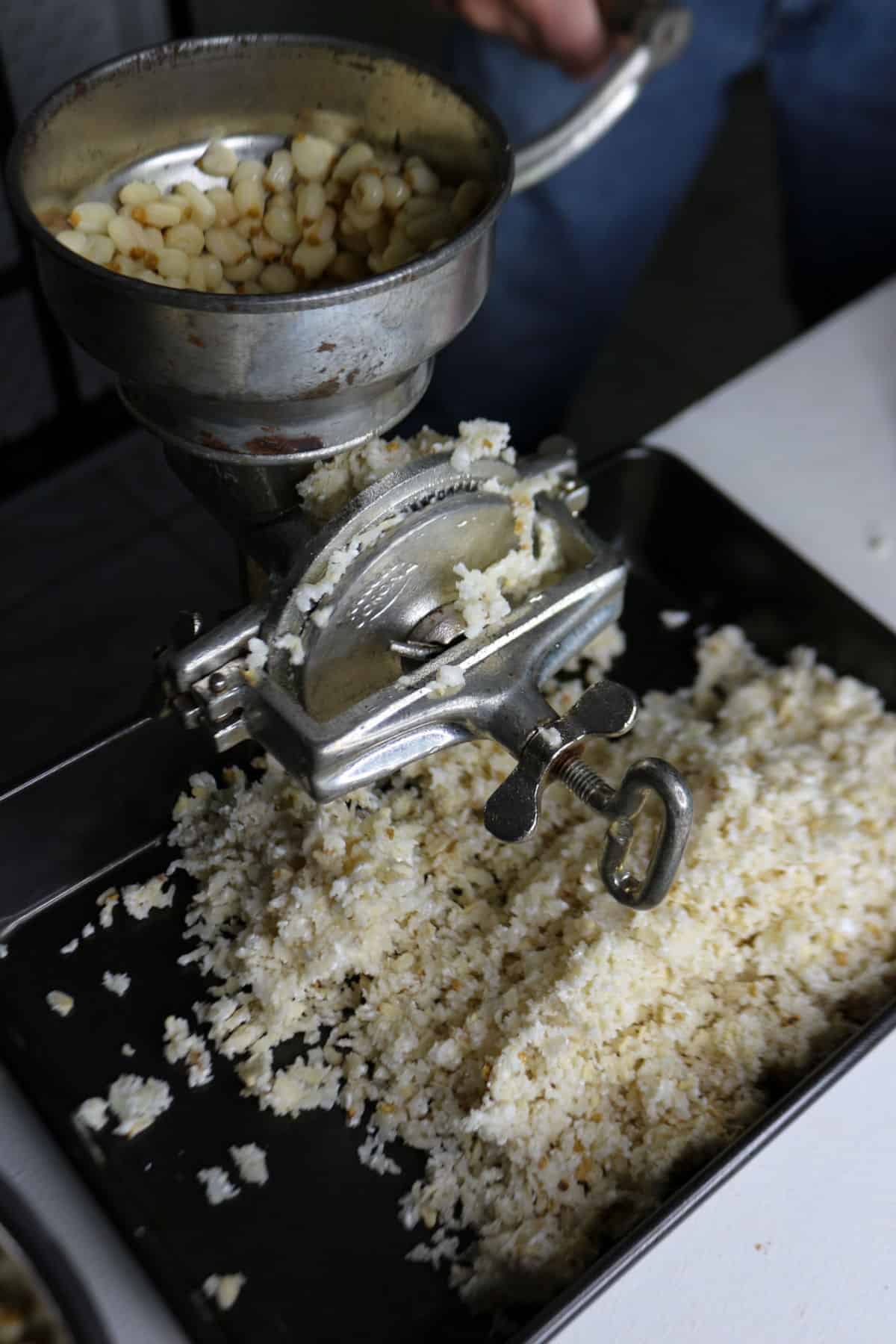 Grinding nixtamalized corn using a hand-crank mill