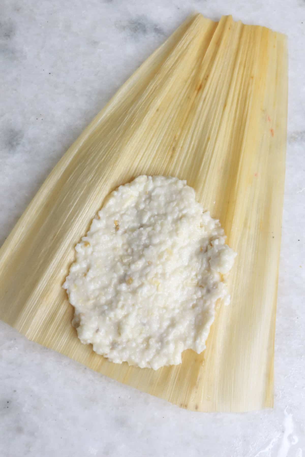 Masa for tamales spread on a corn husk