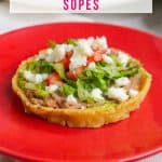 Mexican refried bean sope on a red plate