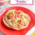 A red plate with a Mexican refried bean tostada