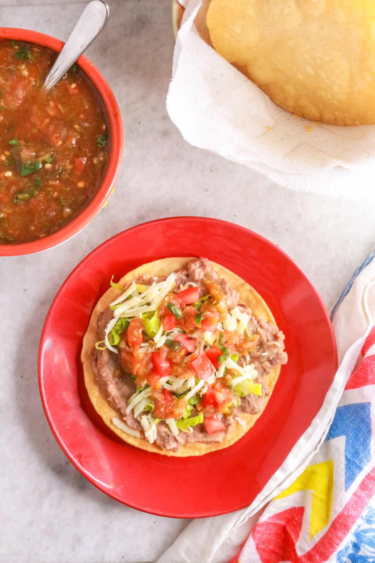 Top view of a prepared bean tostada on a plate