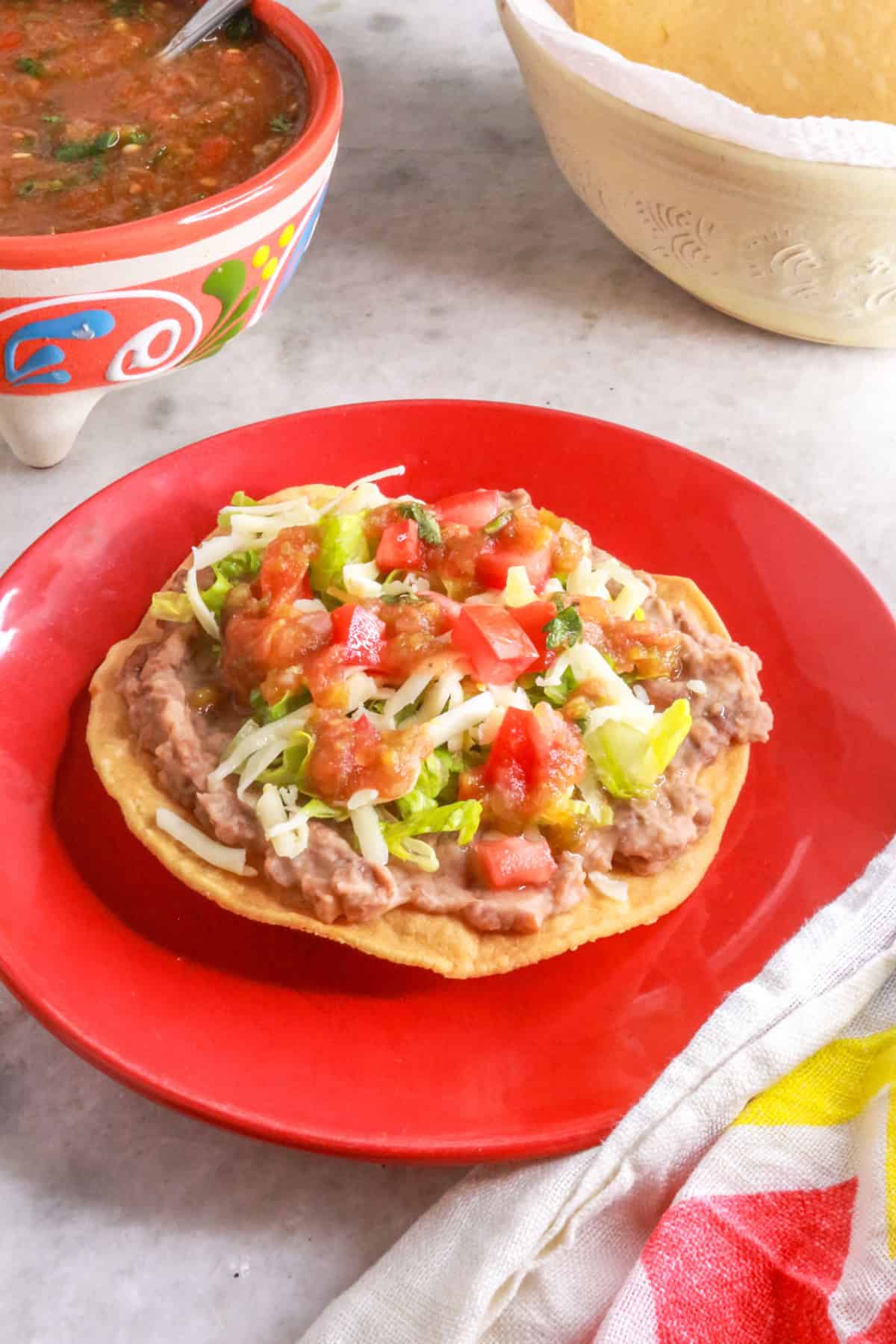Tostadas de Frijoles on a red plate