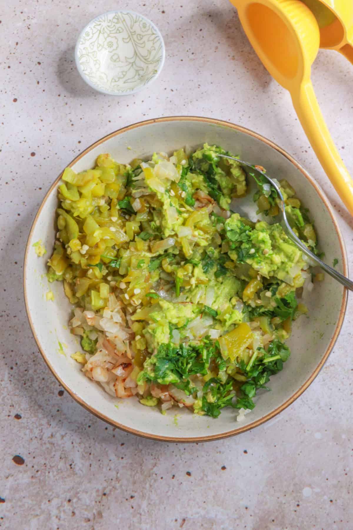 Mixing ingredients in a bowl for green chile guacamole