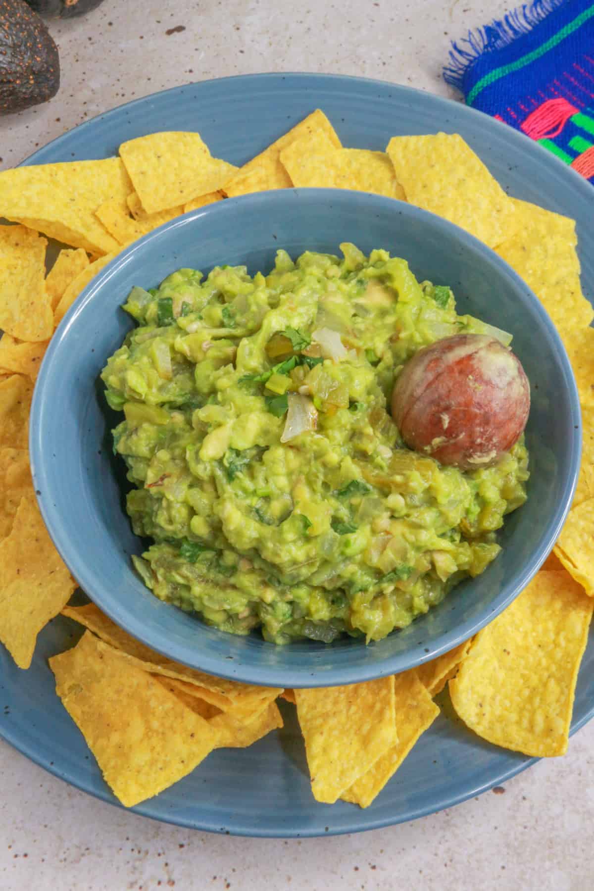 Green Chile guacamole in a bowl surrounded by tortilla chips