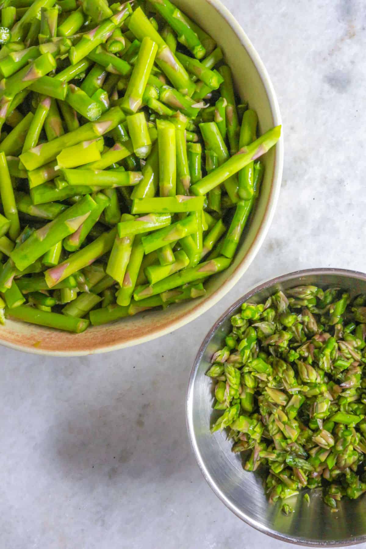 two bowl with cut asparagus