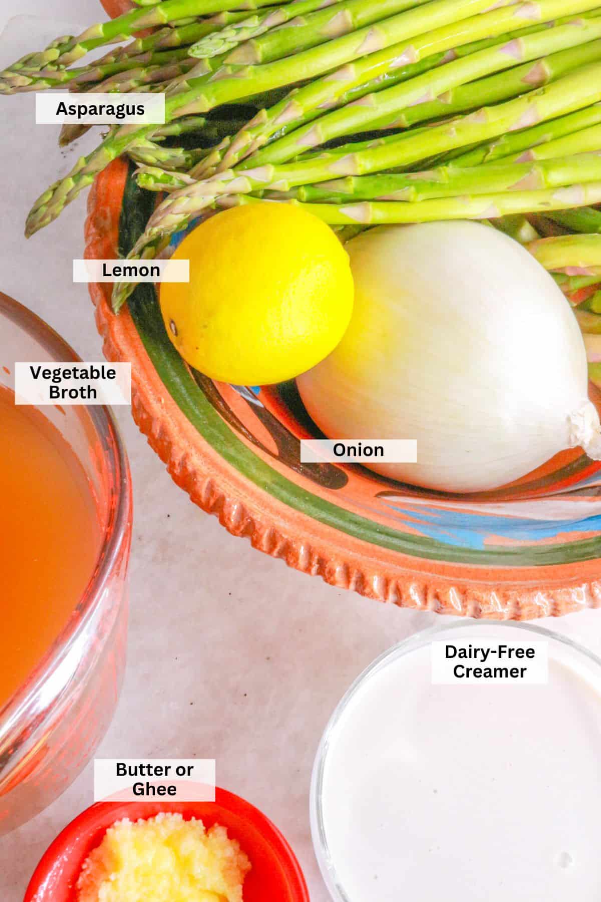 Ingredients for crema de espárragos soup: asparagus, lemon, onion, broth, cream, butter