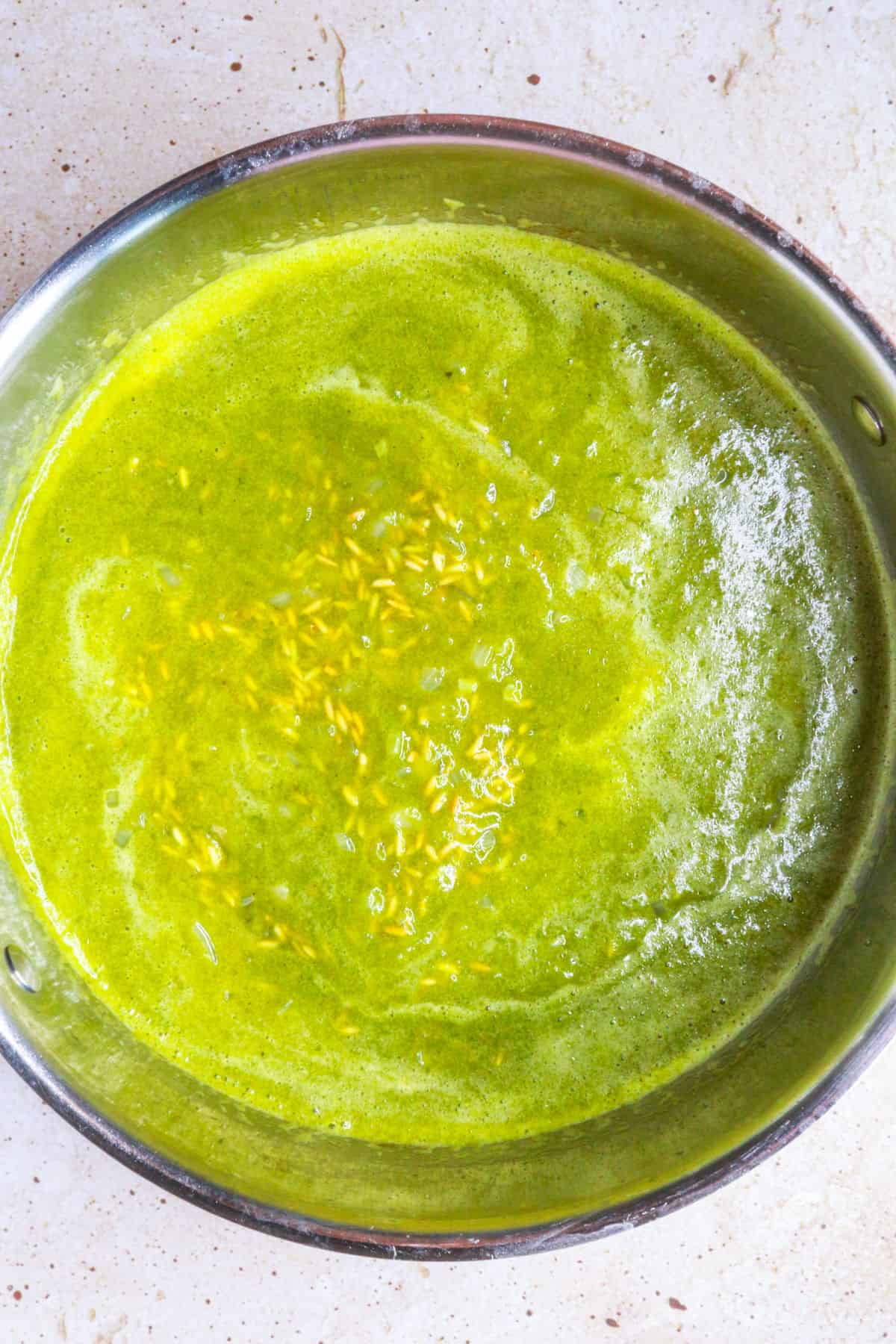 Rice in a pan covered with poblano sauce