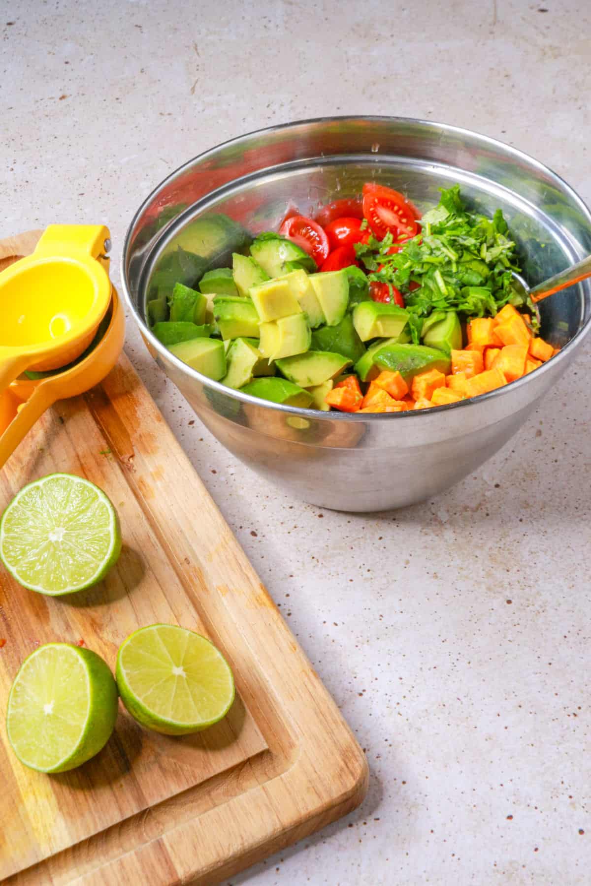 Cutting board with cut limes and the sweet potato salad in the background