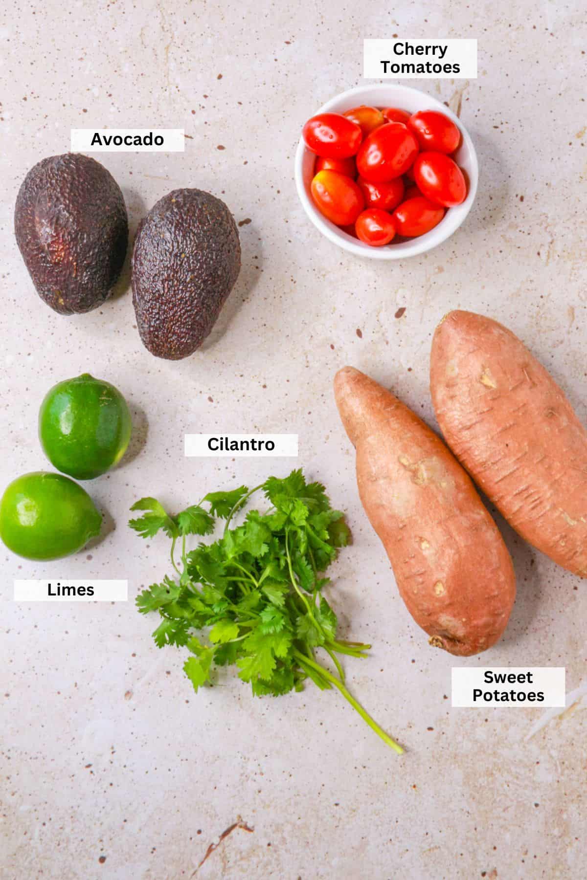 Ingredients for ensalada de camote: cherry tomatoes, avocados, sweet potatoes, limes, cilantro