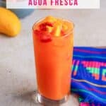 Glass of strawberry mango Agua Fresca garnished with pieces of fruit