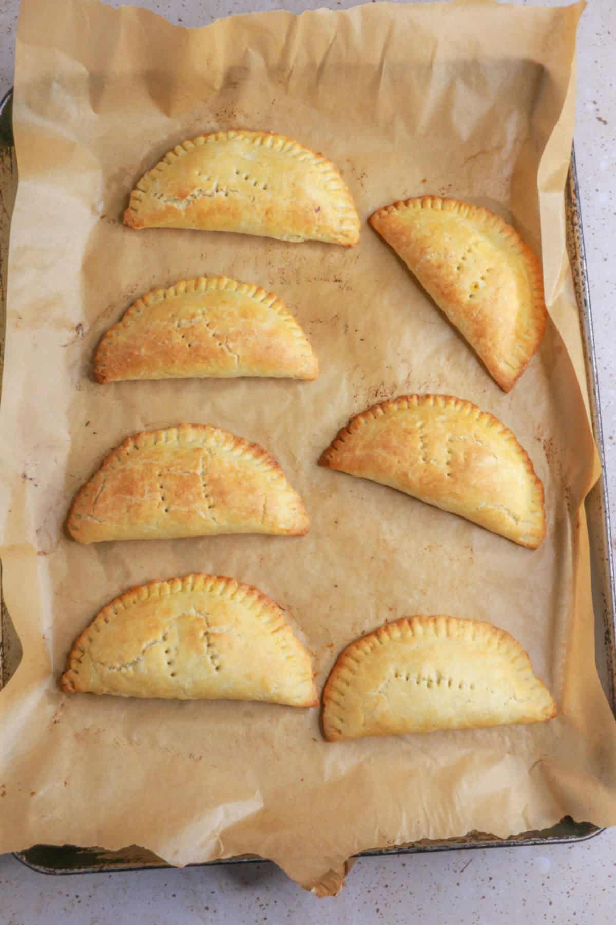 Baked empanadas on a baking sheet