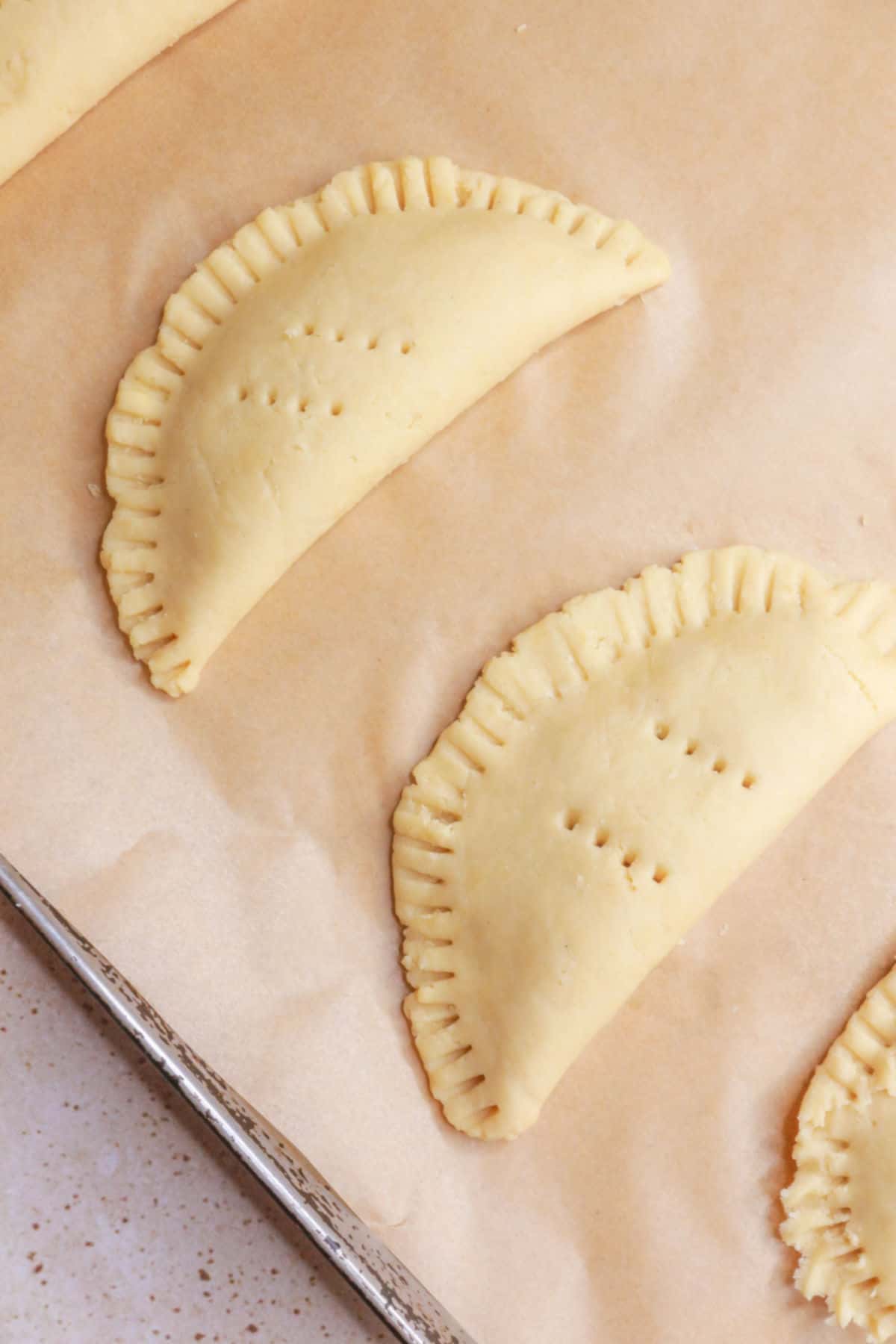 Empanadas on parchment paper ready to bake