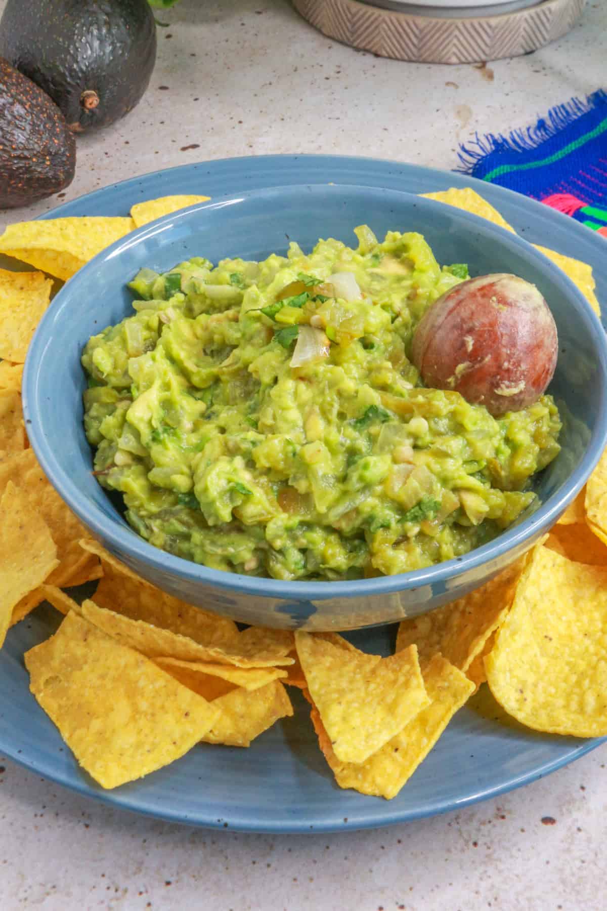 Green Chile guacamole in a bowl surrounded by tortilla chips