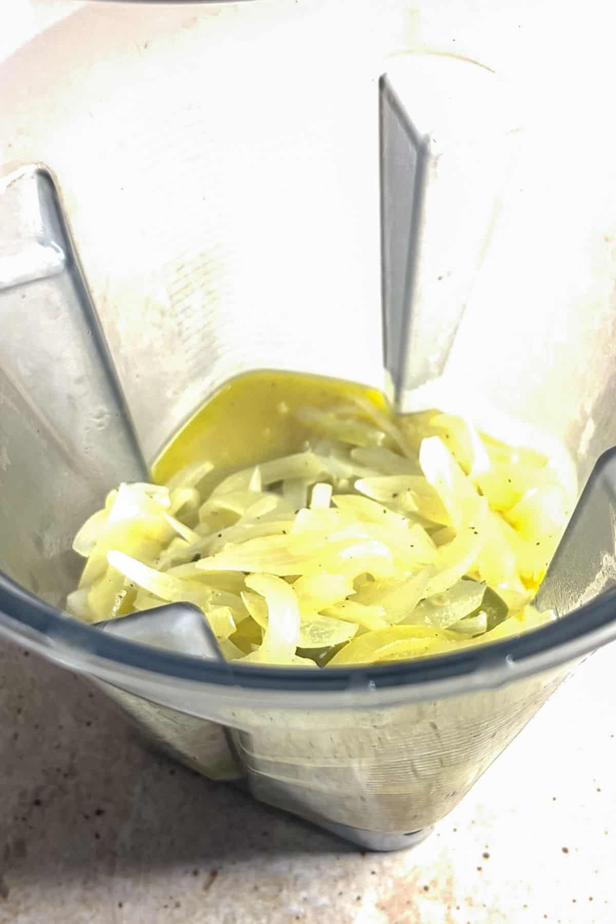 Adding ingredients for creamy onion soup to a blender