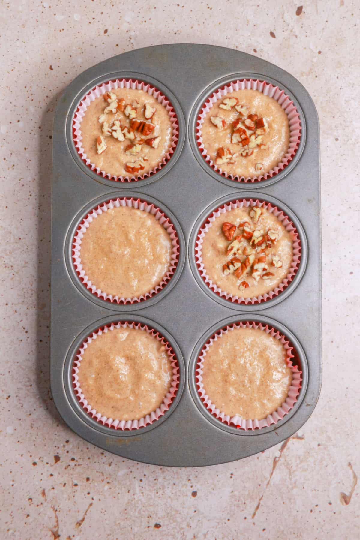 Unbaked muffins de manzana in a muffin tin