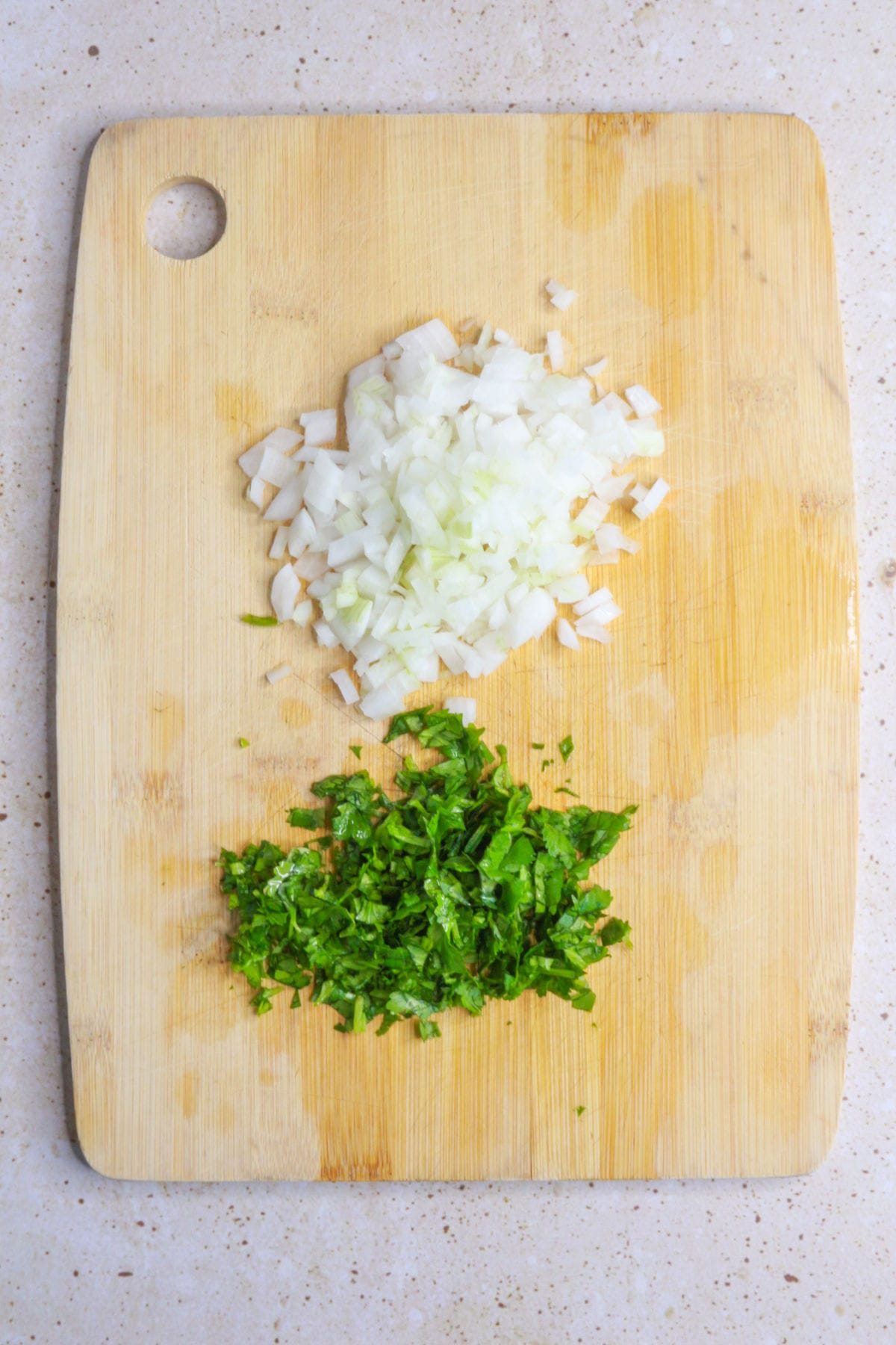 diced cilantro and onion on a wooden cutting board
