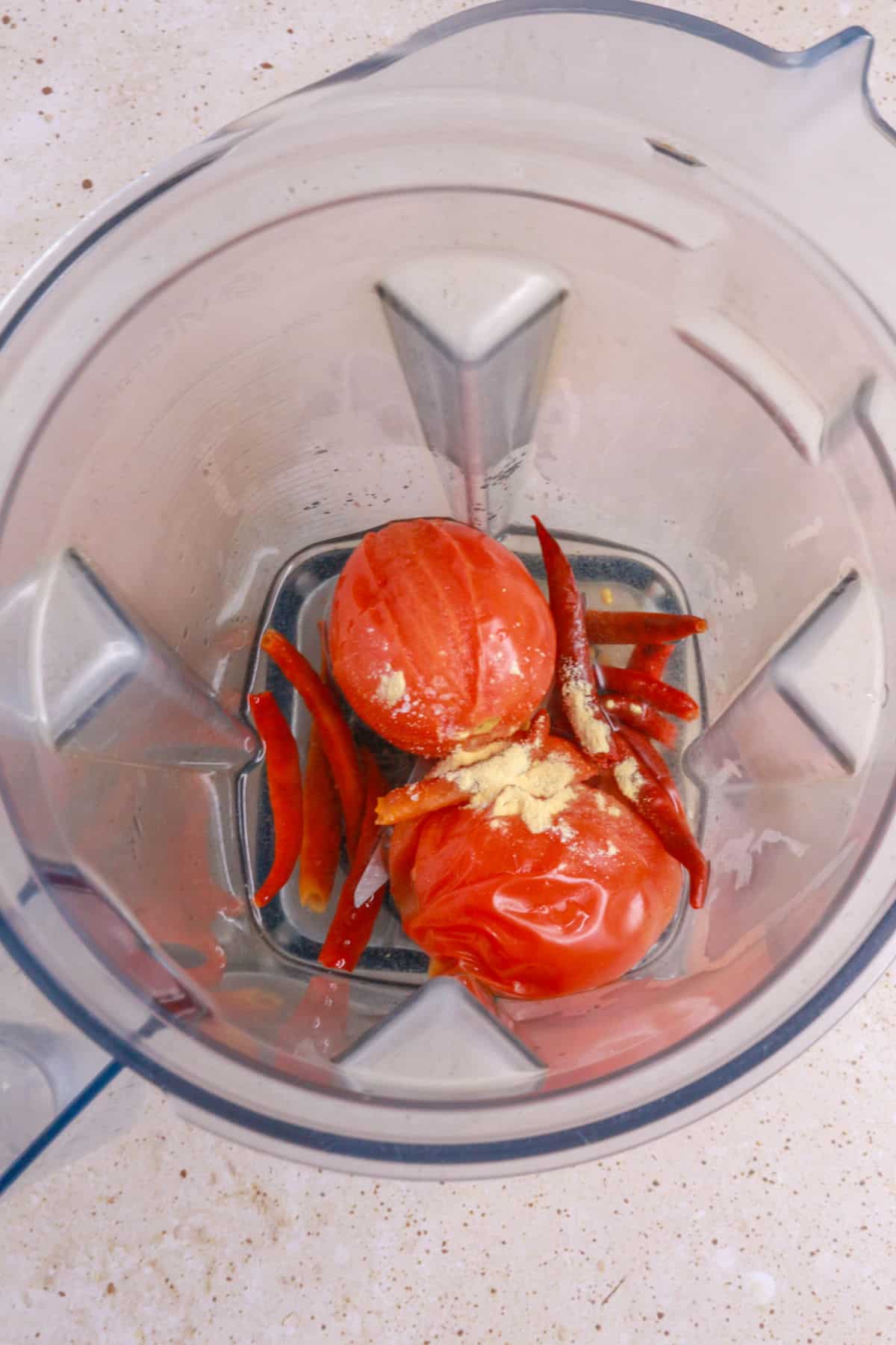 chiles de arbol, tomatoes and garlic powder in a blender
