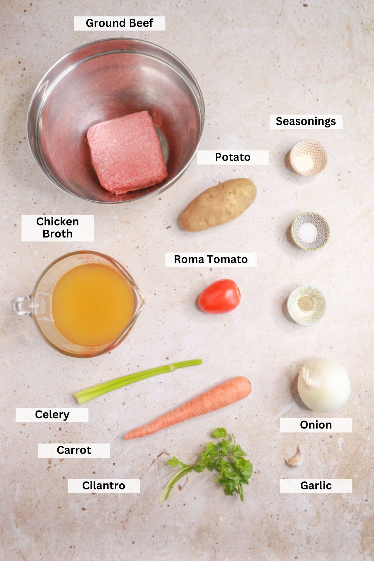 Ingredients for caldo de albondigas: ground beef, potato, seasonings, chicken broth, celery, onion, garlic, Roma tomato, carrot, cilantro