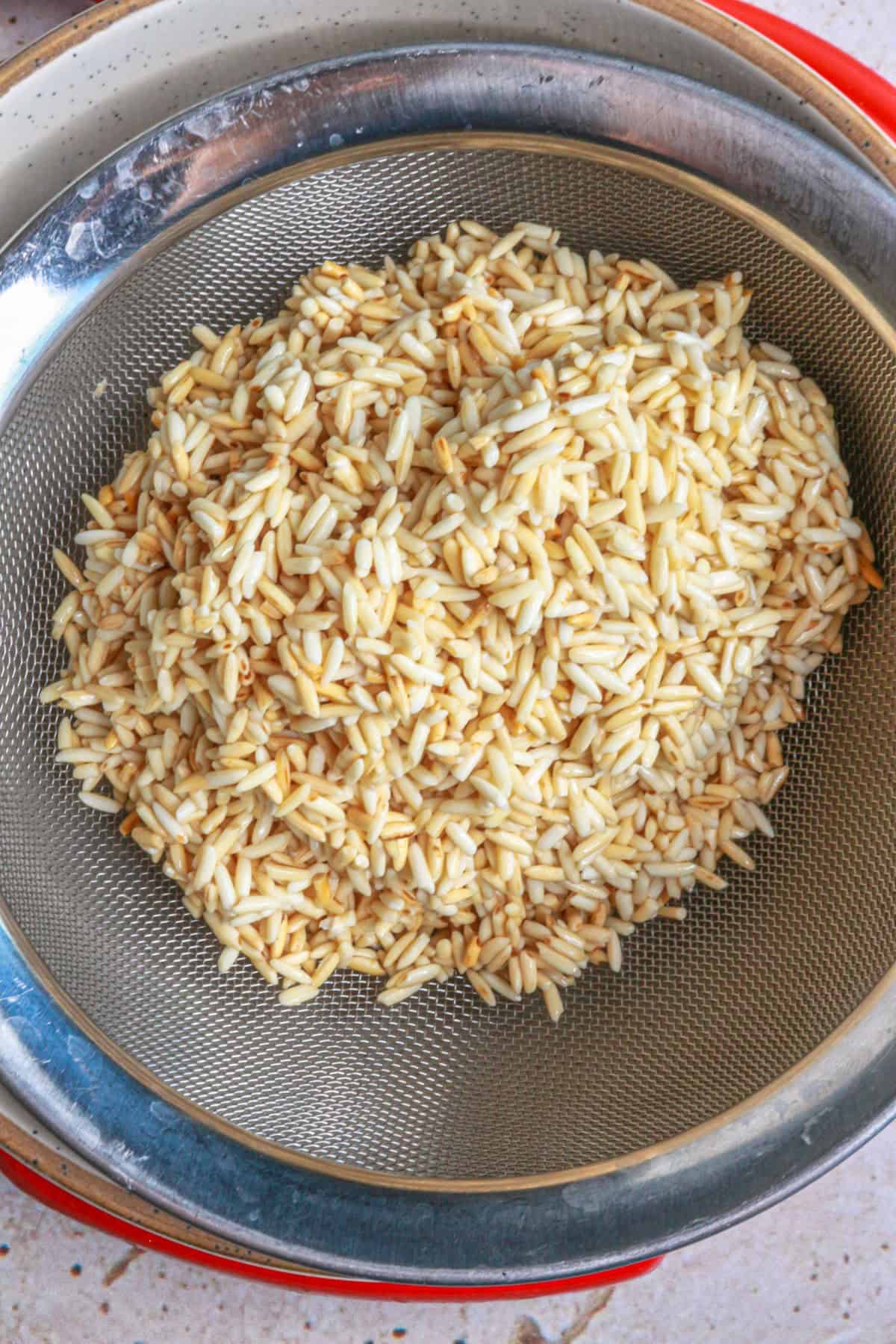 Place rice in a strainer and strain the oil
