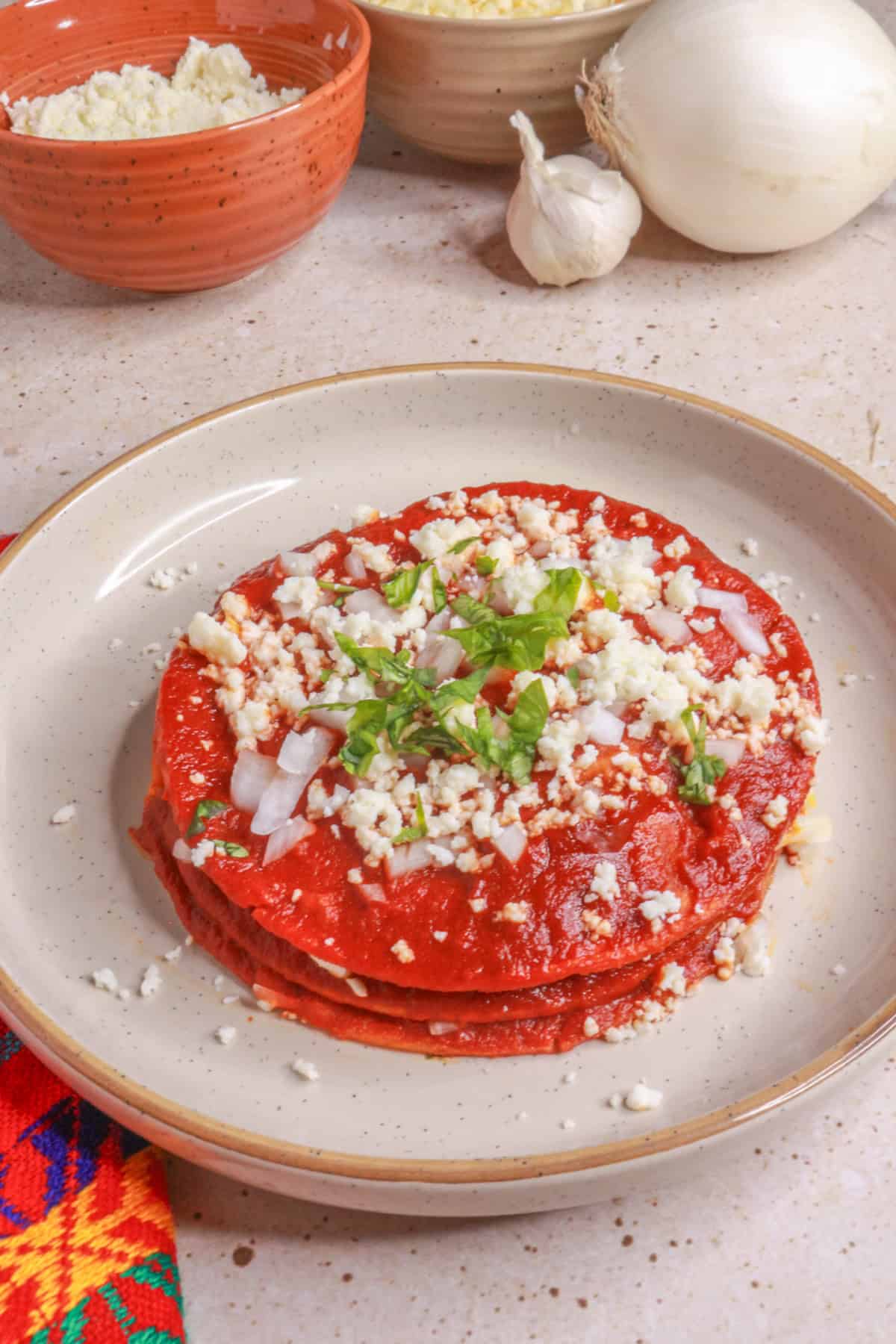 Stacked enchiladas with red sauce