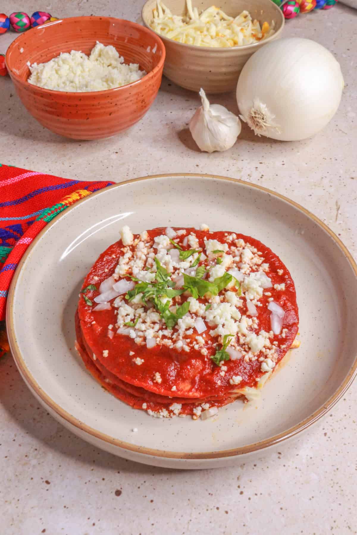 Stacked Enchiladas with red guajillo chile sauce on a plate