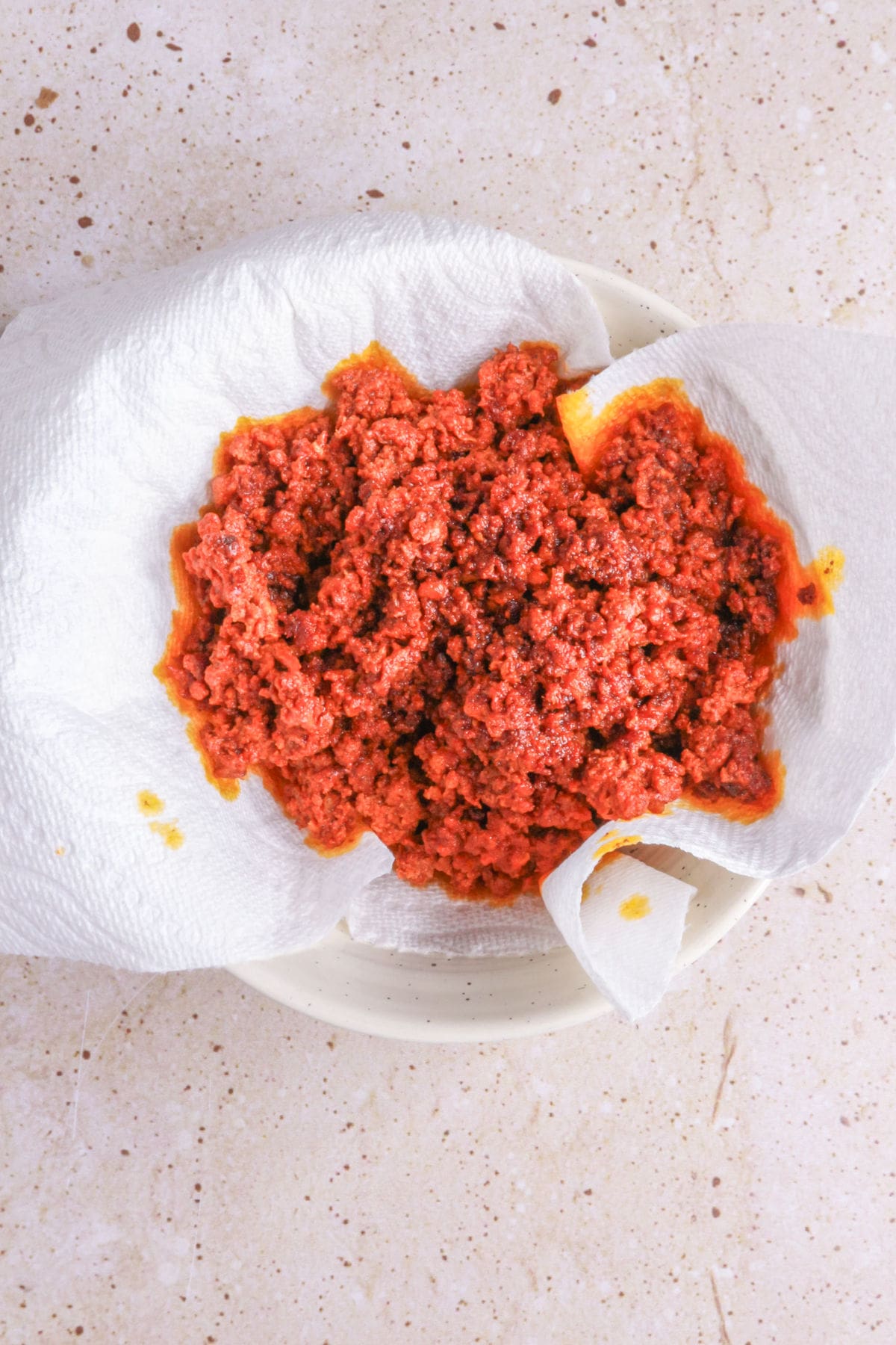 Draining chorizo on a paper towel-lined plate