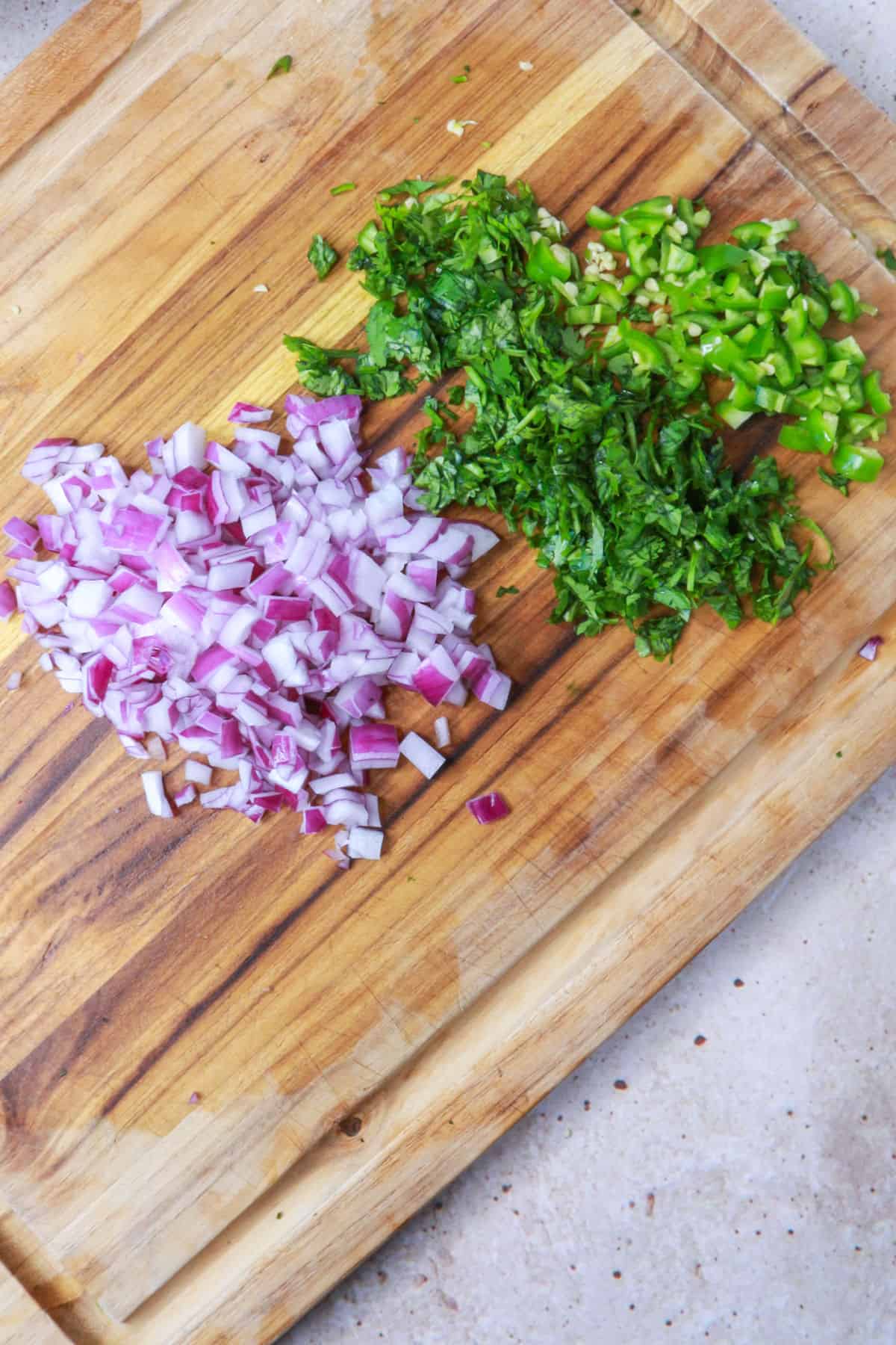 Diced red onion, cilantro and serranos on cutting board