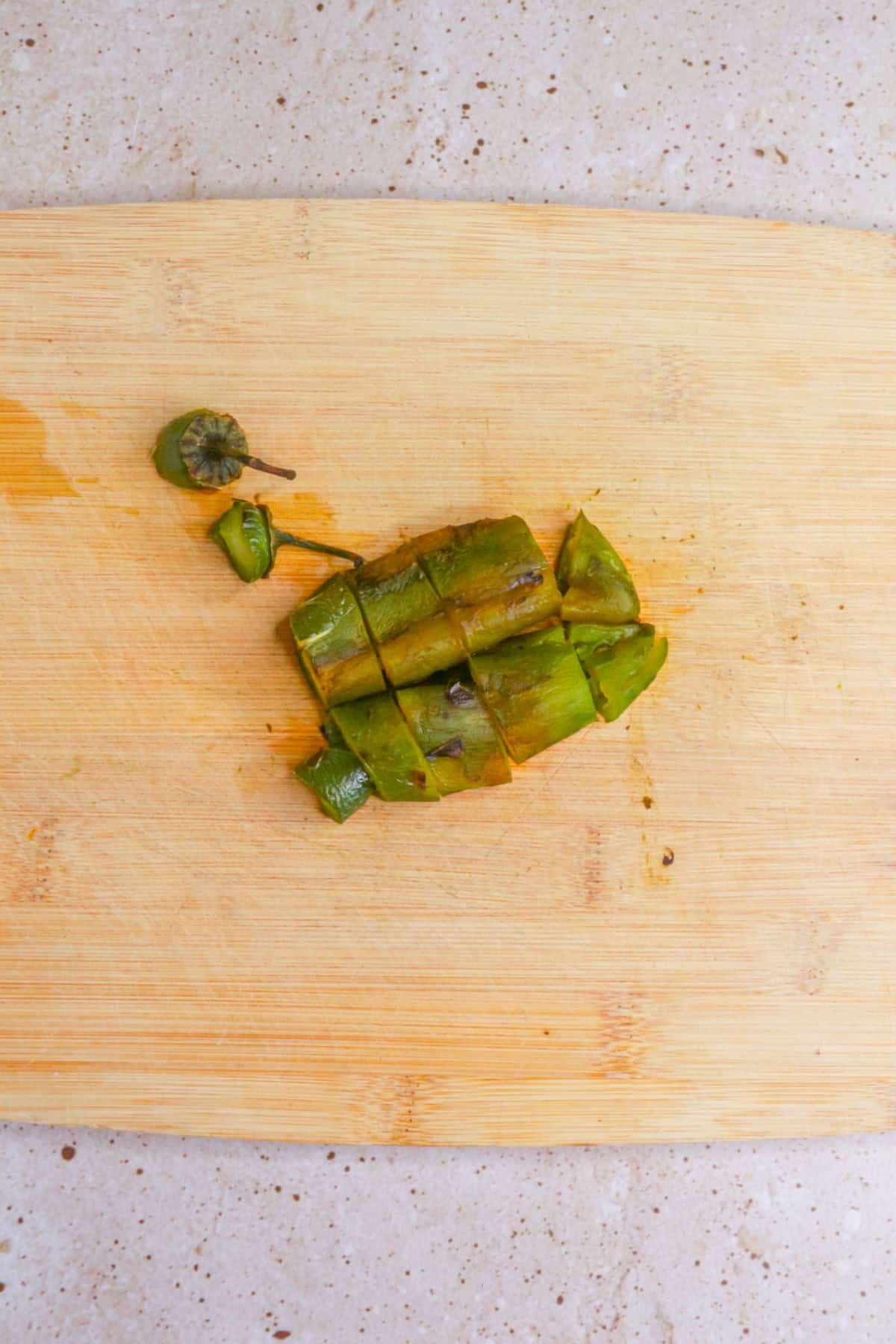 Chopped roasted jalapeños on a cutting board