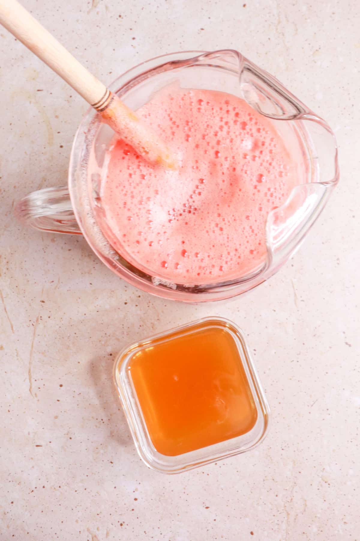 Pineapple watermelon agua fresca in a pitcher and a container of honey simple syrup
