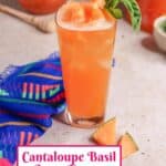 a glass of cantaloupe basil Agua Fresca garnished with pieces of melon and basil leaves