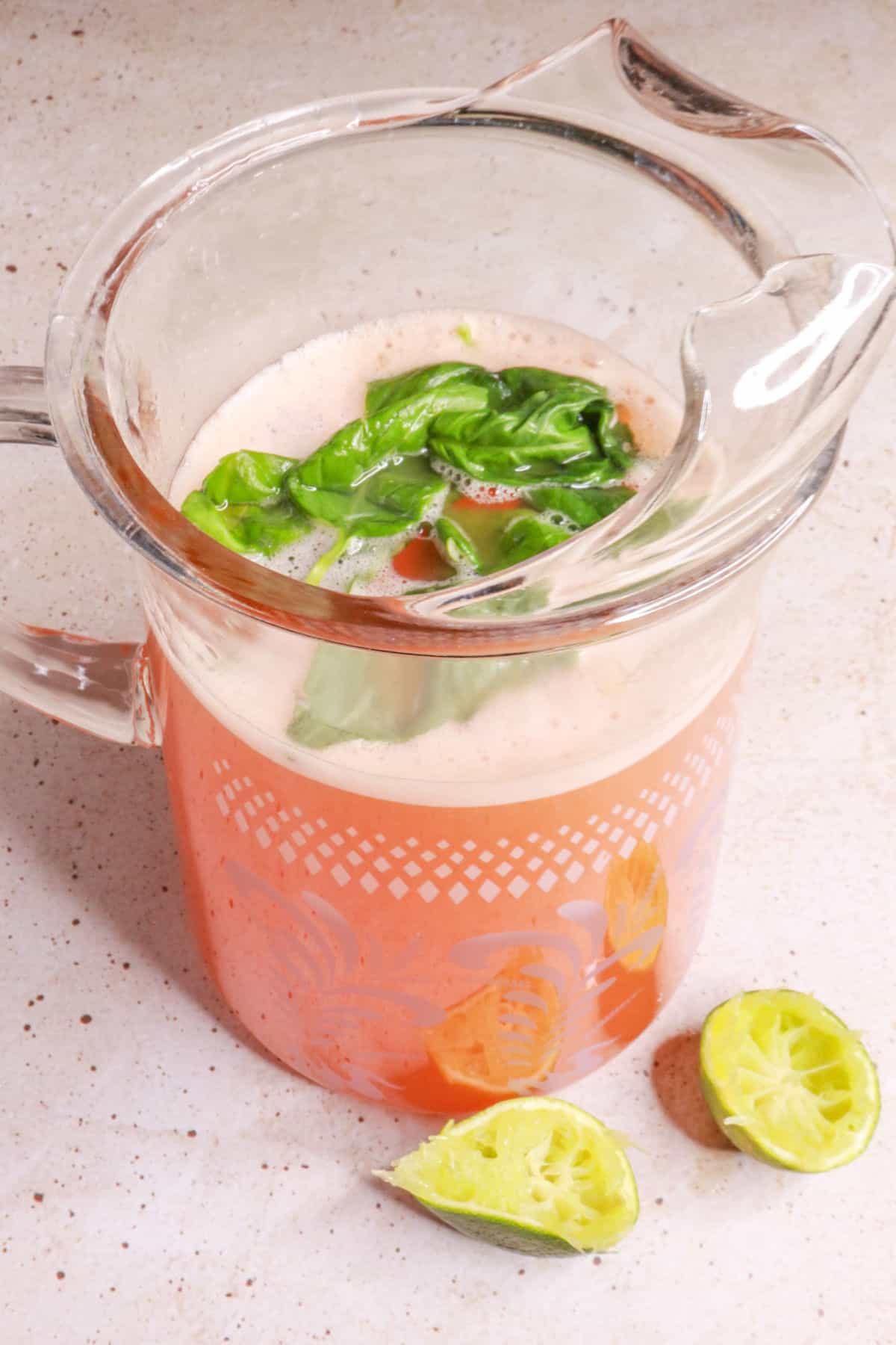 pitcher of cantaloupe agua fresca with basil leaves